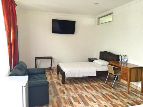 1 dormitorio con cama, mesa y sofá en Monteverde Hotel, en La Dorada