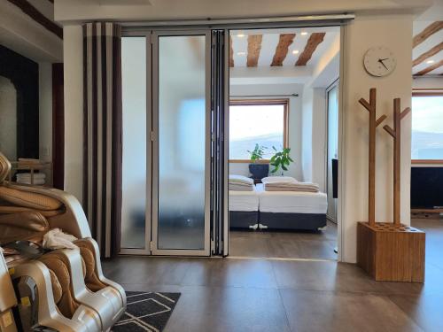 a bedroom with a bed and sliding glass doors at Palm Tree Villa in Seogwipo