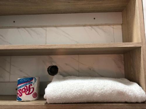 a shelf with a can of coke and a towel at Capsule Queens Luxury Studio in Mombasa