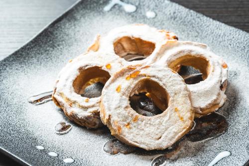 two donuts covered in powdered sugar on a plate at KOKO HOTEL Premier Kanazawa Korinbo in Kanazawa