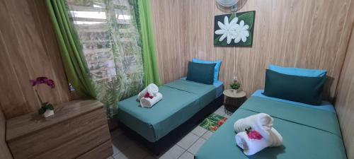 a room with two beds with pillows on them at Tauraatini House F4 - PAPEETE in Papeete