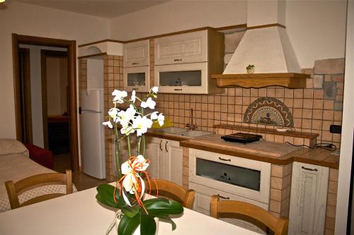 a kitchen with a table with a vase of flowers at Ca' Del Sasso in Verona