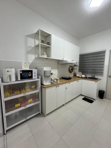 バターワースにあるKN Homestayのキッチン(白いキャビネット、白い電化製品付)