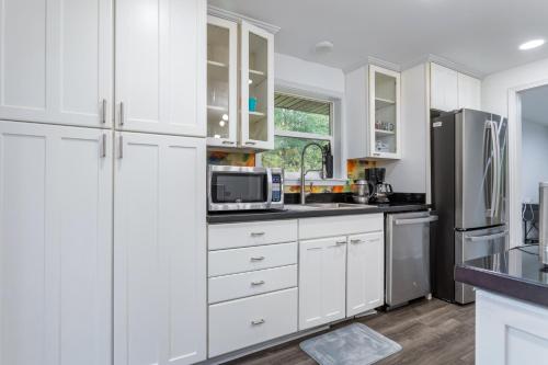 a white kitchen with white cabinets and a refrigerator at Family friendly house with MIL suite in Sammamish