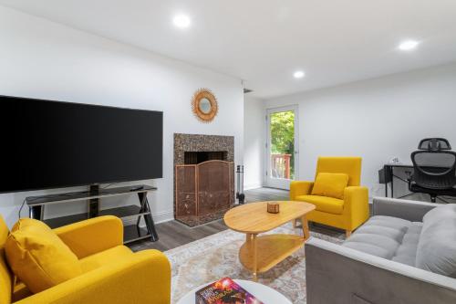 a living room with a flat screen tv and yellow chairs at Family friendly house with MIL suite in Sammamish