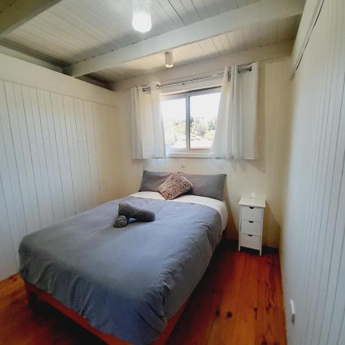 a bed in a small room with a window at Beachouse in Lock Sport
