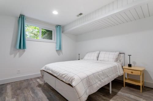 a white bedroom with a bed and a window at Family friendly house with MIL suite in Sammamish