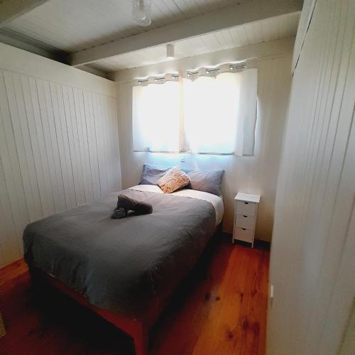 a small bedroom with a bed with a window at Beachouse in Lock Sport