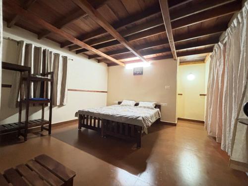 a bedroom with a bed in a room with wooden ceilings at The Perch - Daisy Land in Madikeri