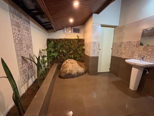a bathroom with a toilet and a sink and a plant at The Perch - Daisy Land in Madikeri