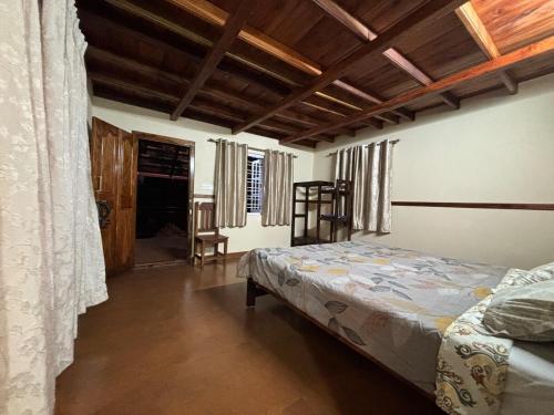 a bedroom with a bed and a wooden ceiling at The Perch - Daisy Land in Madikeri