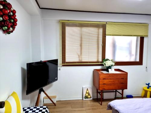 a living room with a flat screen tv and a dresser at Y202 & B201 near Hongdae Univ Station in Seoul