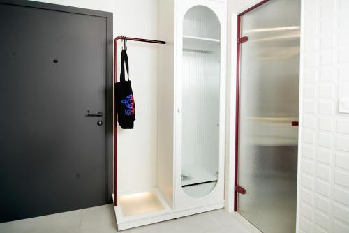 un armadio bianco con specchio e borsa nera di BoX 27 a Kalamáta