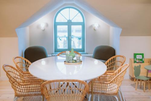 a dining room with a white table and chairs at Saieta 2 Apartments in Madona