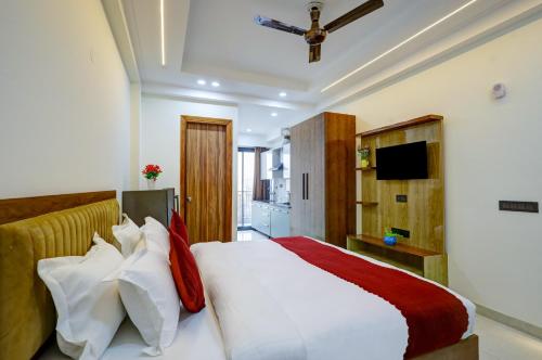 a bedroom with a white bed with red and white pillows at Royal Residency - Medanta in Gurgaon