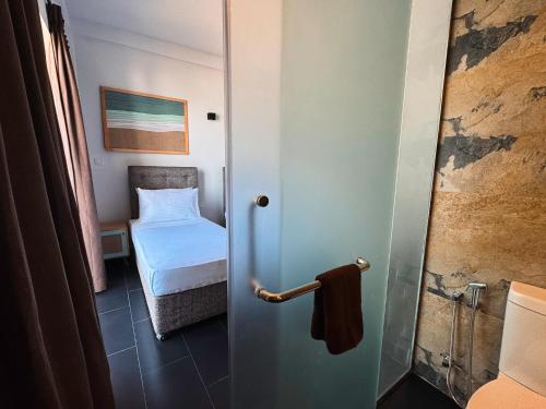 a bathroom with a door to a bedroom with a bed at Moi Induruwa by DBI in Bentota