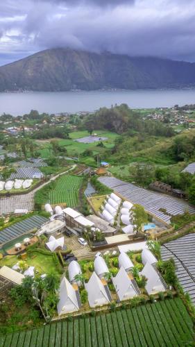 an aerial view of a farm with a body of water at The Dewi Kintamani Luxury Glamping and Natural Hotspring in Kintamani