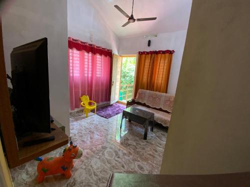 a living room with a couch and a flat screen tv at Dreaminn family homestay in Meenangadi