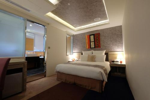 a hotel room with a bed and a window at V-one Vogue Hotel in Taipei