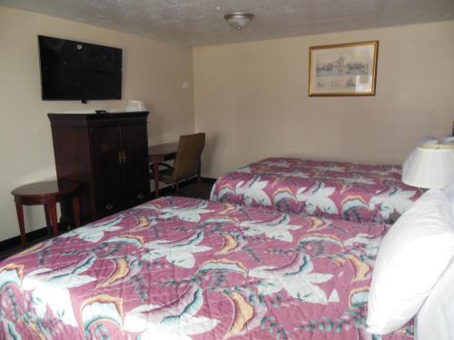 a hotel room with a bed and a flat screen tv at Route 66 Inn in Amarillo