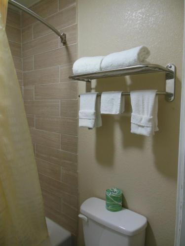 a bathroom with a toilet with towels on a shelf at Route 66 Inn in Amarillo