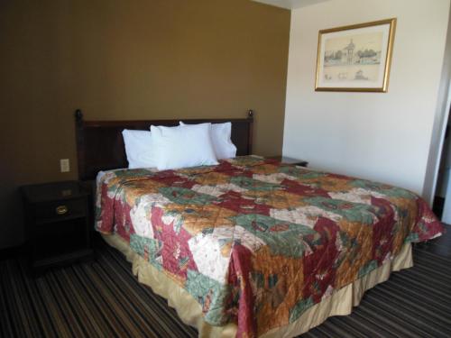 a hotel room with a bed with a quilt on it at Route 66 Inn in Amarillo