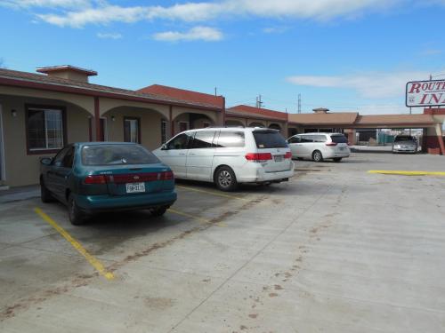 two cars parked in a parking lot in front of a store at Route 66 Inn in Amarillo