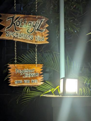 a sign hanging from a pole with a light at Kottayil back water villa in Pāppinisseri