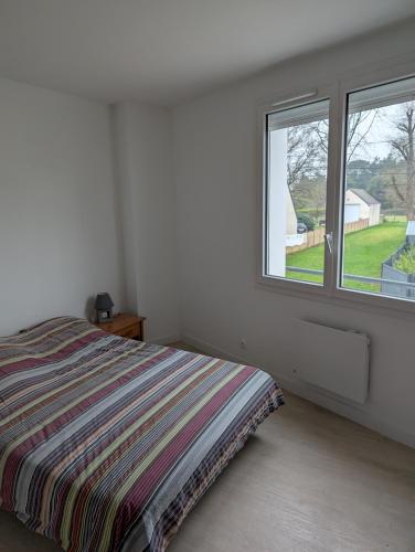 une chambre blanche avec un lit et une fenêtre dans l'établissement Appartement 2 chambres 4 personnes, à Sainte-Reine-de-Bretagne