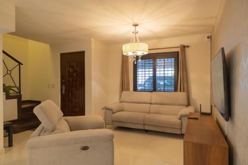 a living room with a couch and a chair at Refugio Elegante y Equipado en Zona Dorada in Mexicali