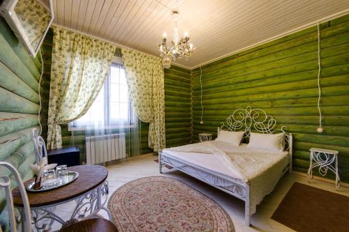 1 dormitorio con paredes verdes, 1 cama y 1 mesa en Villa LUI-JO, en Krasnodar