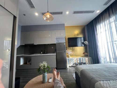 a person with their feet on a table in a bedroom at Căn hộ Homestay riêng tư khu Oceanpark Gia Lâm in Gia Lâm Pho