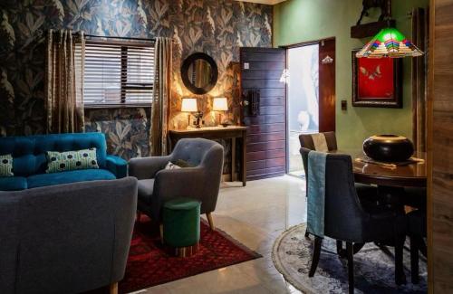 a living room with a blue couch and chairs at Rarebird Waverley in Bloemfontein
