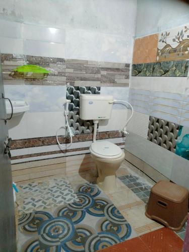 a bathroom with a toilet in a room at GOLDENGARDEN COTTAGES in Hampi