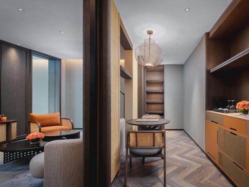 a living room with a table and a chair at Hotel Indigo Yantai Golden Coast by IHG in Yantai