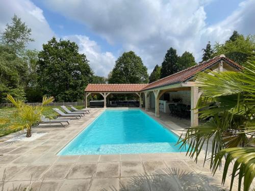 une piscine avec des chaises et un gazebo dans l'établissement Beautiful renovated villa 2024 Air-conditioned pool SPA, à Bourdonné
