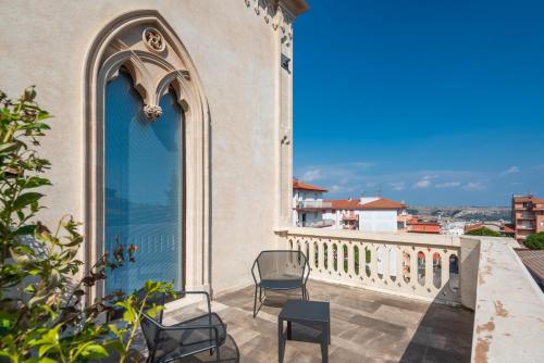 a balcony with two chairs and a blue door at Villa Boscarino Boutique Hotel & Spa in Ragusa