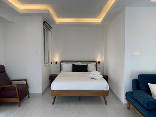 a bedroom with a bed and two blue chairs at CS Junction Point - Special Day Room SDR in Kuala Pilah