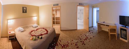 a room with a bed with a cake and a desk at Park Hotel Latgola in Daugavpils