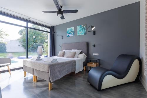 une chambre avec un lit et une chaise dans l'établissement Secret Lovely, à Seysses