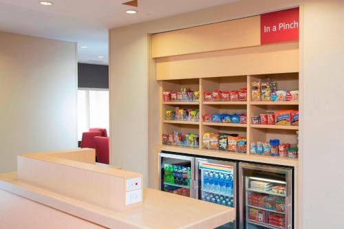 a store with a counter with a refrigerator at TownePlace Suites by Marriott Kalamazoo in Portage