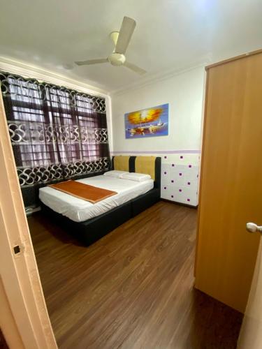 a small bedroom with a bed and a window at The Fortune Homestay in Kota Kinabalu