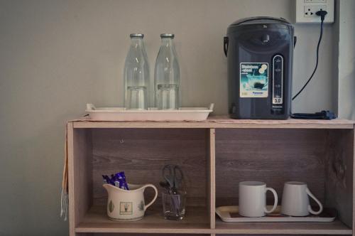 a shelf with two bottles and a coffee maker on it at ComeOn Stay&Sleep in Chiang Rai