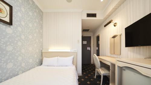 a hotel room with a bed and a desk at Hotel Paco Obihiro Ekimae in Obihiro