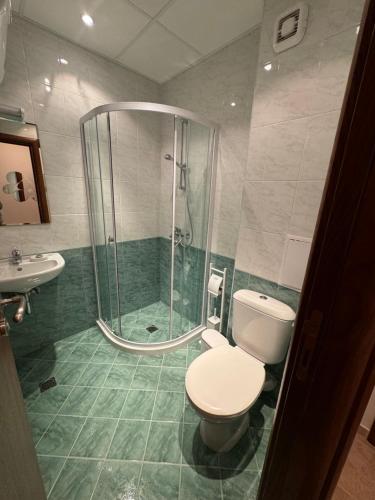 een badkamer met douche, toilet en wastafel bij Pirin Sense apartment A11 in Bansko