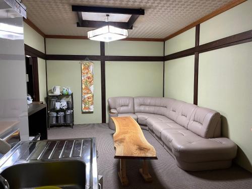 a living room with a couch and a table at Aigakusou in Nozawa Onsen