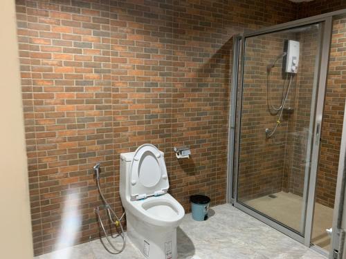 a bathroom with a toilet and a glass shower at sp hotel in Ban Thong Lang (1)