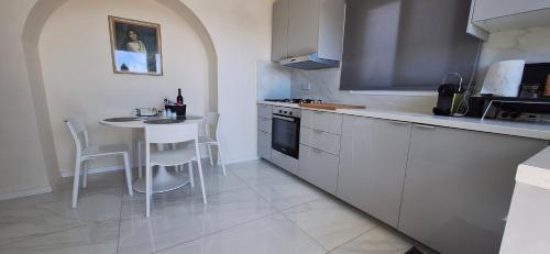 a white kitchen with a table and a counter top at Lydia's Sea View - 2 bed House in Episkopi Lemesou