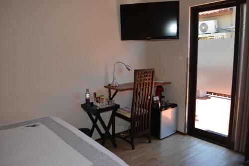 a bedroom with a bed and a chair and a television at GuestHouse 1109 in Maputo