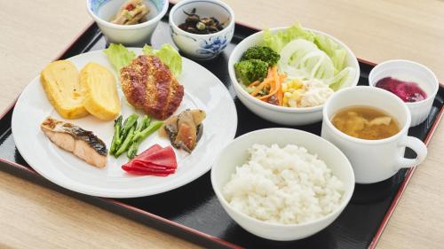 ein Tablett mit einem Teller mit Reis und Gemüse in der Unterkunft Hotel Paco Obihiro Ekimae in Obihiro